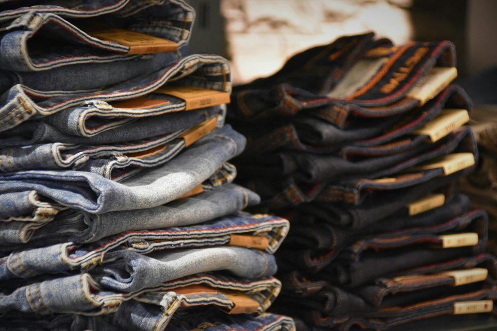 Close-up of folded denim jeans stacked in a retail store setting.